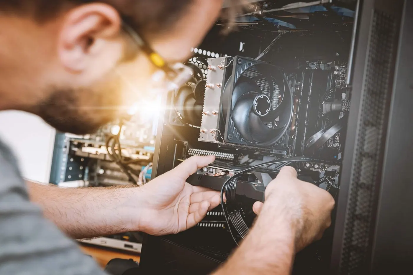 Technician replacing a graphics card in a desktop computer